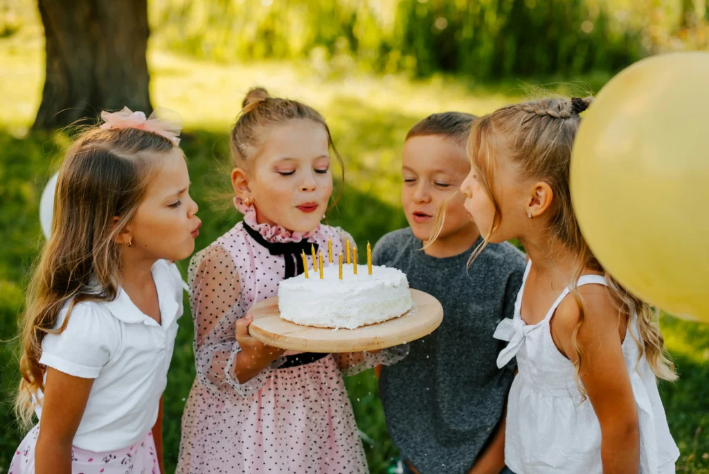 kids blowing out candles at birthday party at the zoo