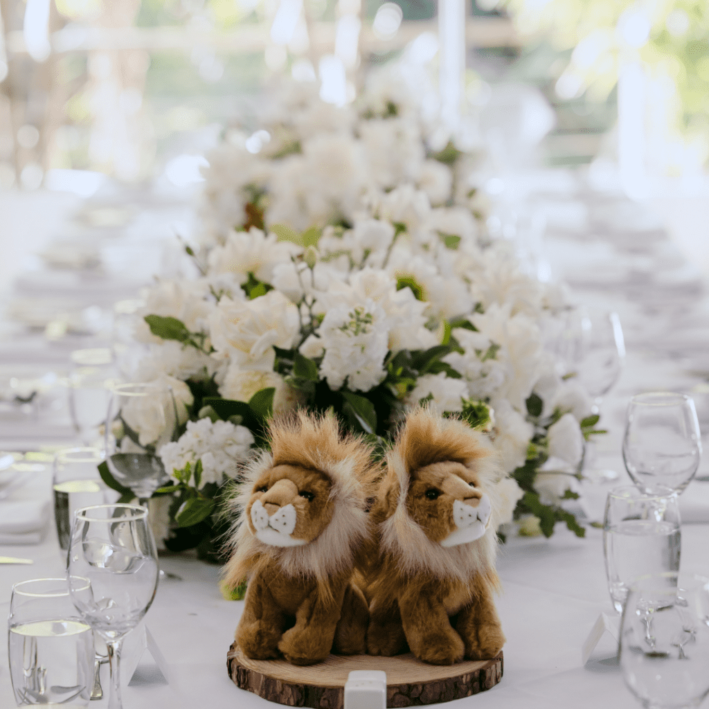 Elegant wedding reception table styling with floral centrepieces and lion keepsakes at Melbourne Zoo