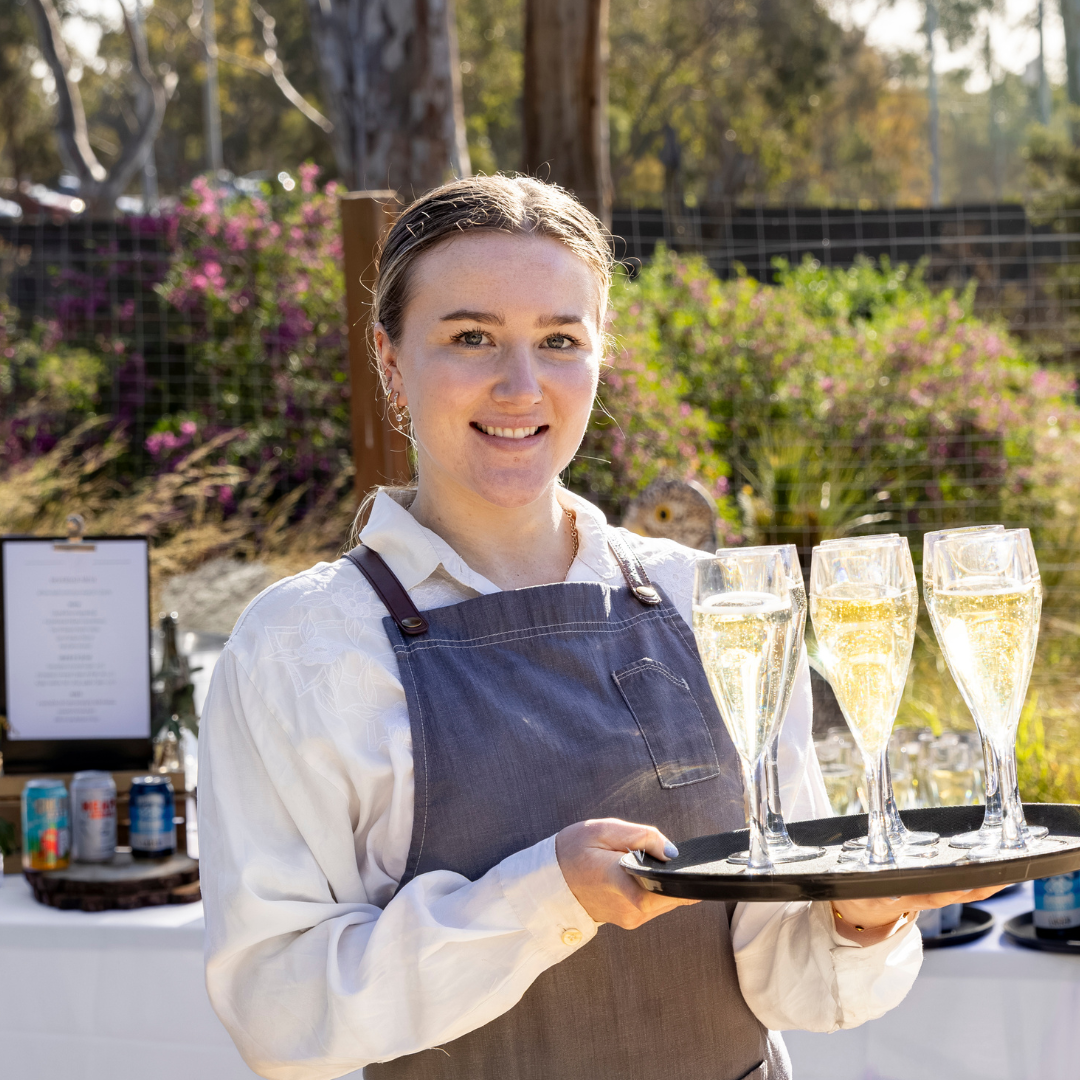 Event staff serving sparkling wine at a corporate event at Melbourne Zoo